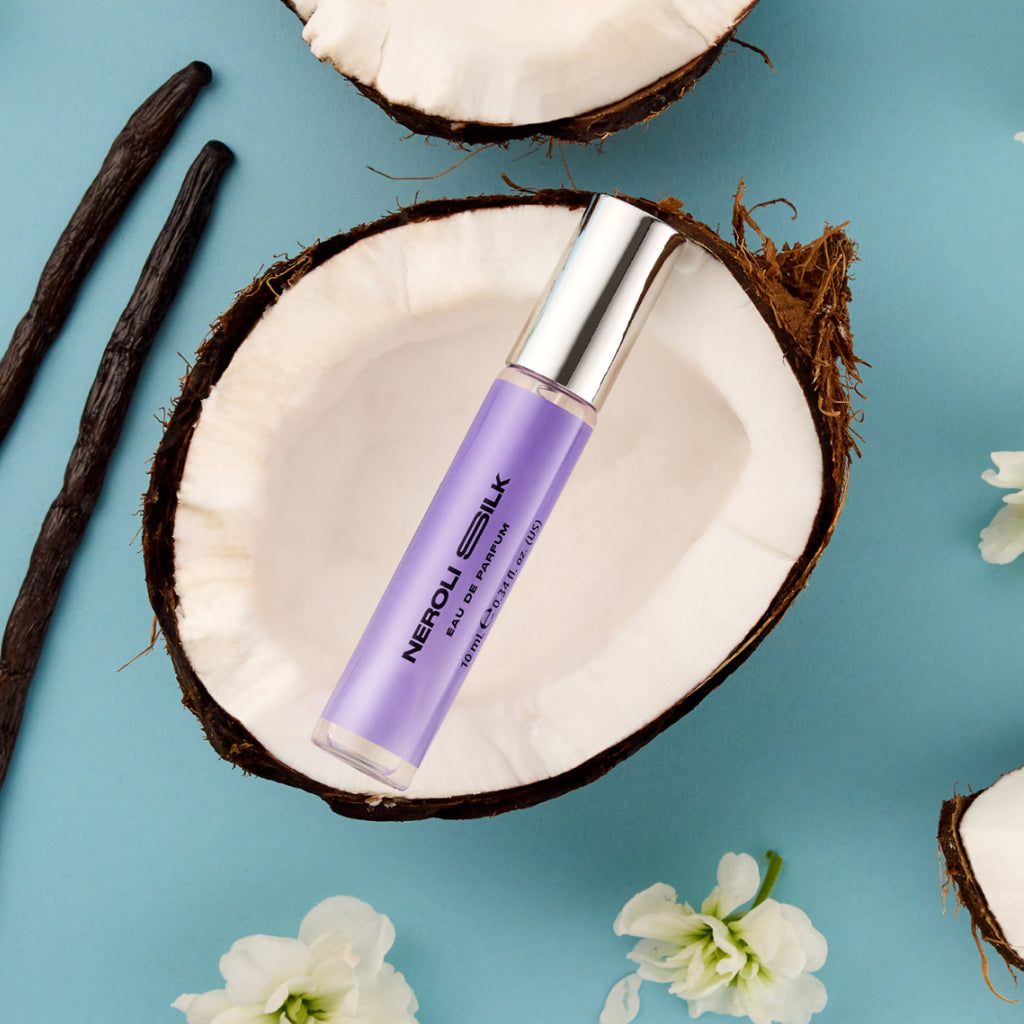 DON.BEAUTY Neroli Silk bottle on a coconut shell with vanilla beans and flowers on a blue background